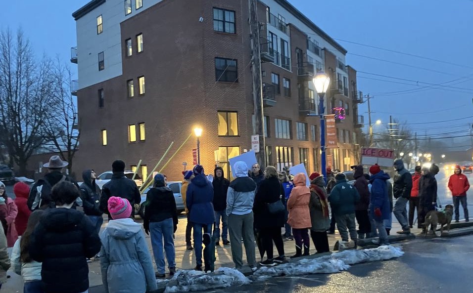 Protesters and singers gather on Bridge Street in Phoenixville, Pa, on a cold winter evening.